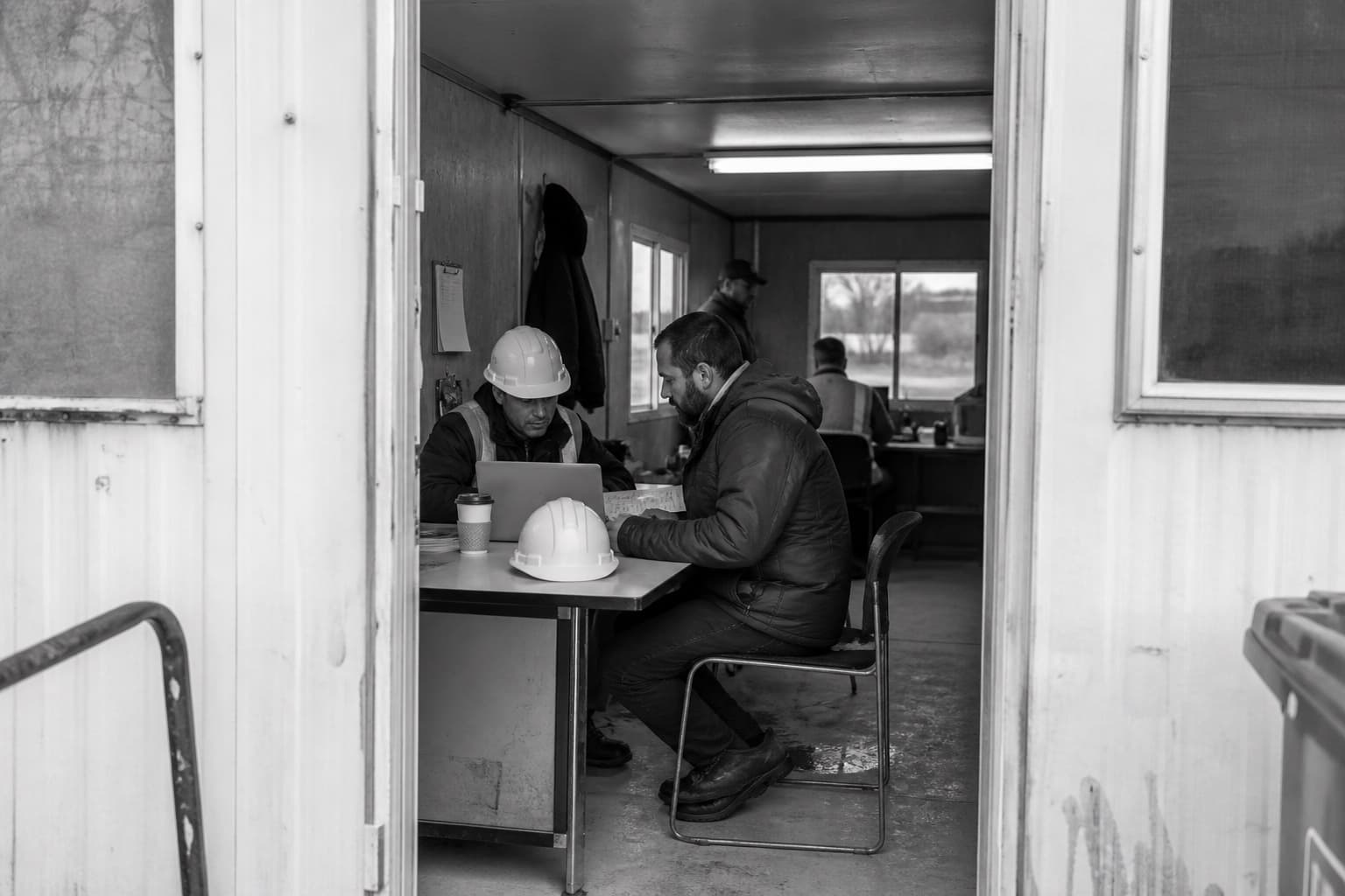 Construction professionals training at a desk inside a jobsite trailer