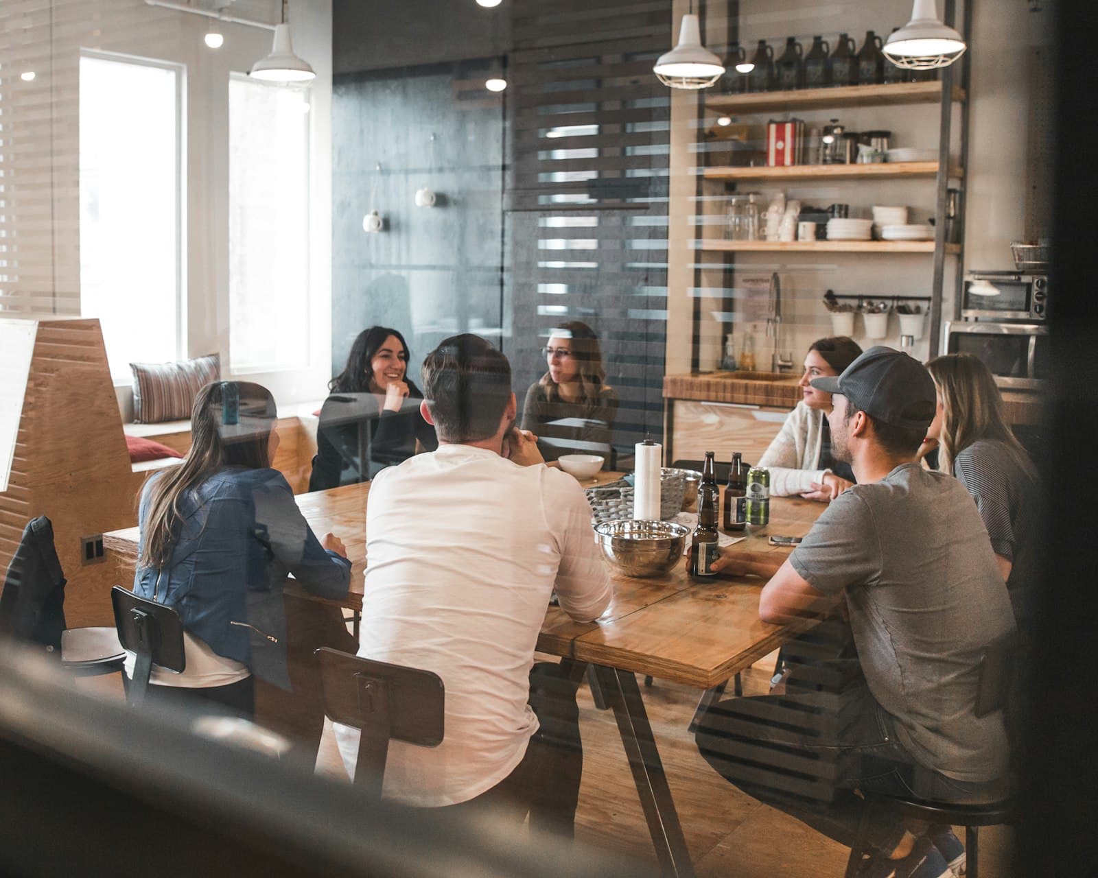 Team collaborating around a table, photographed through glass
